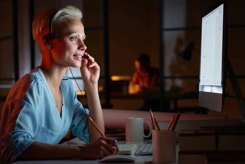 Preview Predictive Dialler Young woman in headphones working on computer while sitting at her workplace