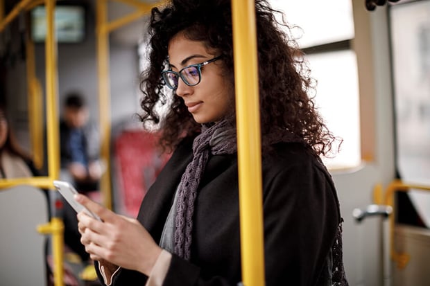 woman on public transportation looking at phone woman on public transportation looking at phone