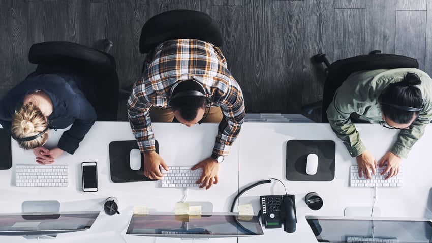 Agentes de contact center Foto en gran angular de un grupo de agentes de call center trabajando en una oficina